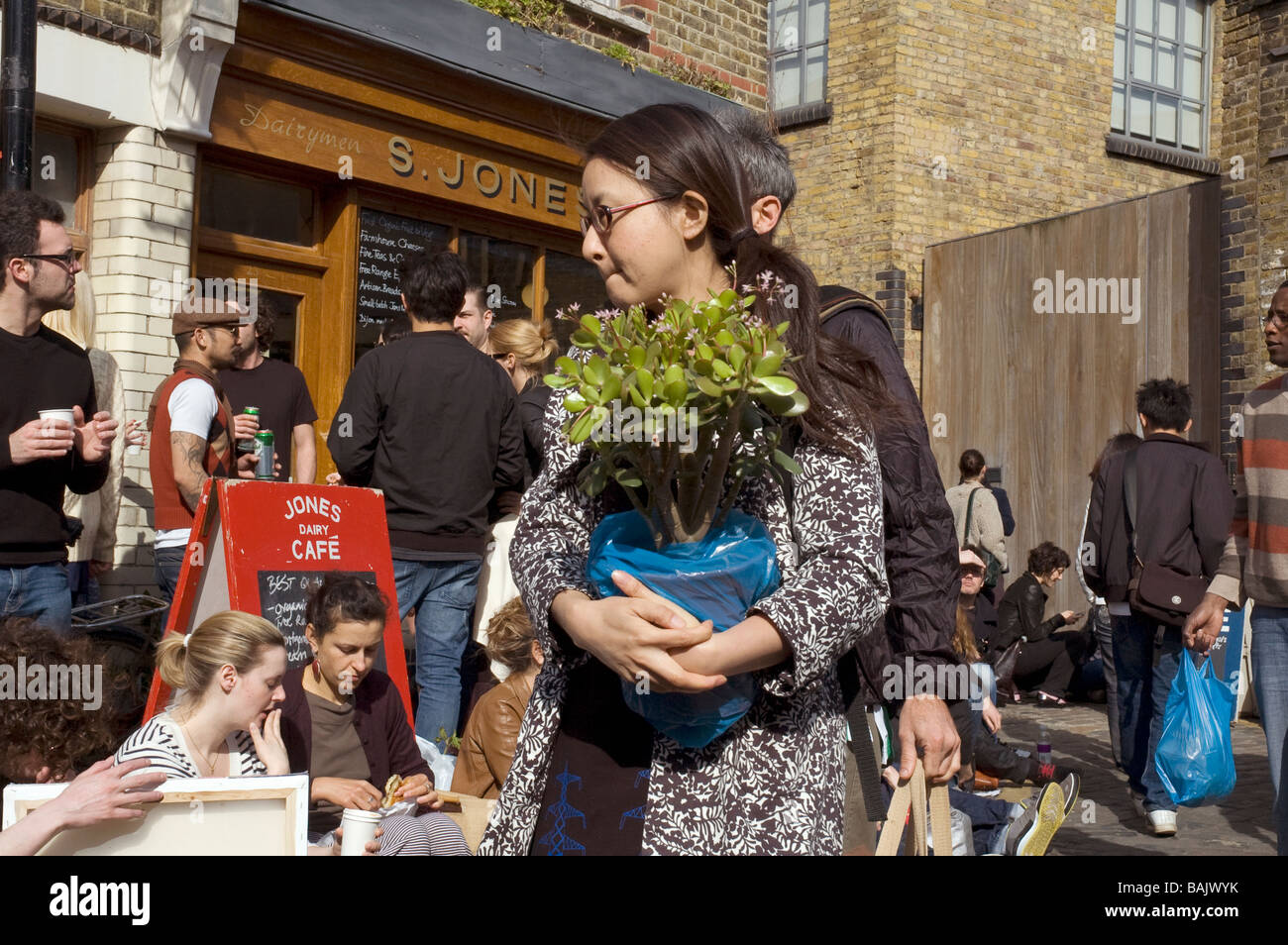 Une femme achète des fleurs sur Columbia Road Flower Market Londres UK Dimanche Banque D'Images