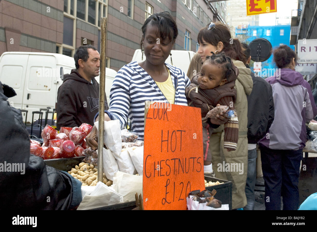 Une mère et son enfant acheter chesnuts Petticoat Lane Street à Londres Angleterre Markeyt Banque D'Images