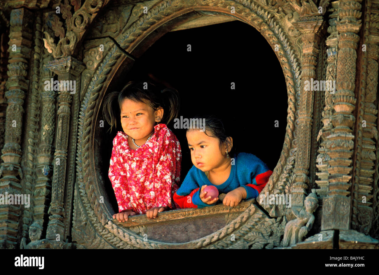 Au Népal, la vallée de Katmandou, Lalitpur, Zone Bagmati, Patan District, petites filles à une fenêtre d'une maison Newar Banque D'Images