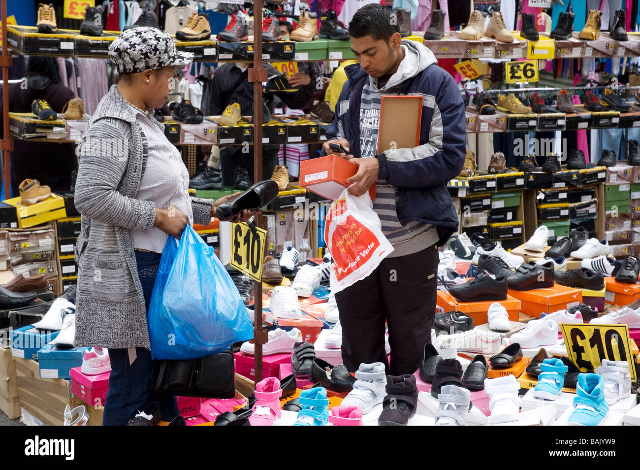 Un wman acheter des chaussures dans le jupon Lane Market Londres dimanche Banque D'Images
