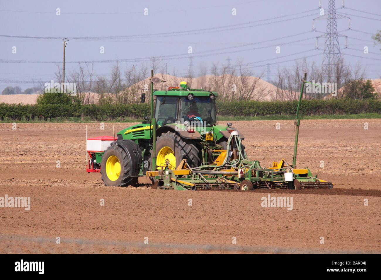 John Deere vert tracteur travaillant dans un champ les semences Banque D'Images