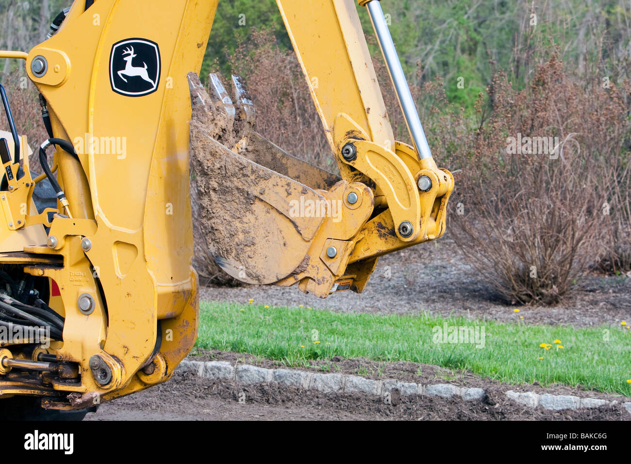 Un tracteur John Deere jaune avec un tas de paillis. La chargeuse pelleteuse avant. Banque D'Images