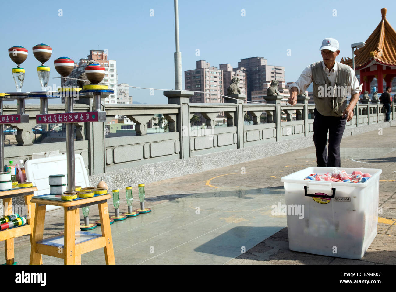 Vente L'HOMME ET DE L'EXÉCUTION SUR UN PONT PLUS TOURISTIQUES EN VILLE SANSIA SPINNING JOUETS EN BOIS TRADITIONNEL SUR LES BOUTEILLES à l'ENVERS Banque D'Images