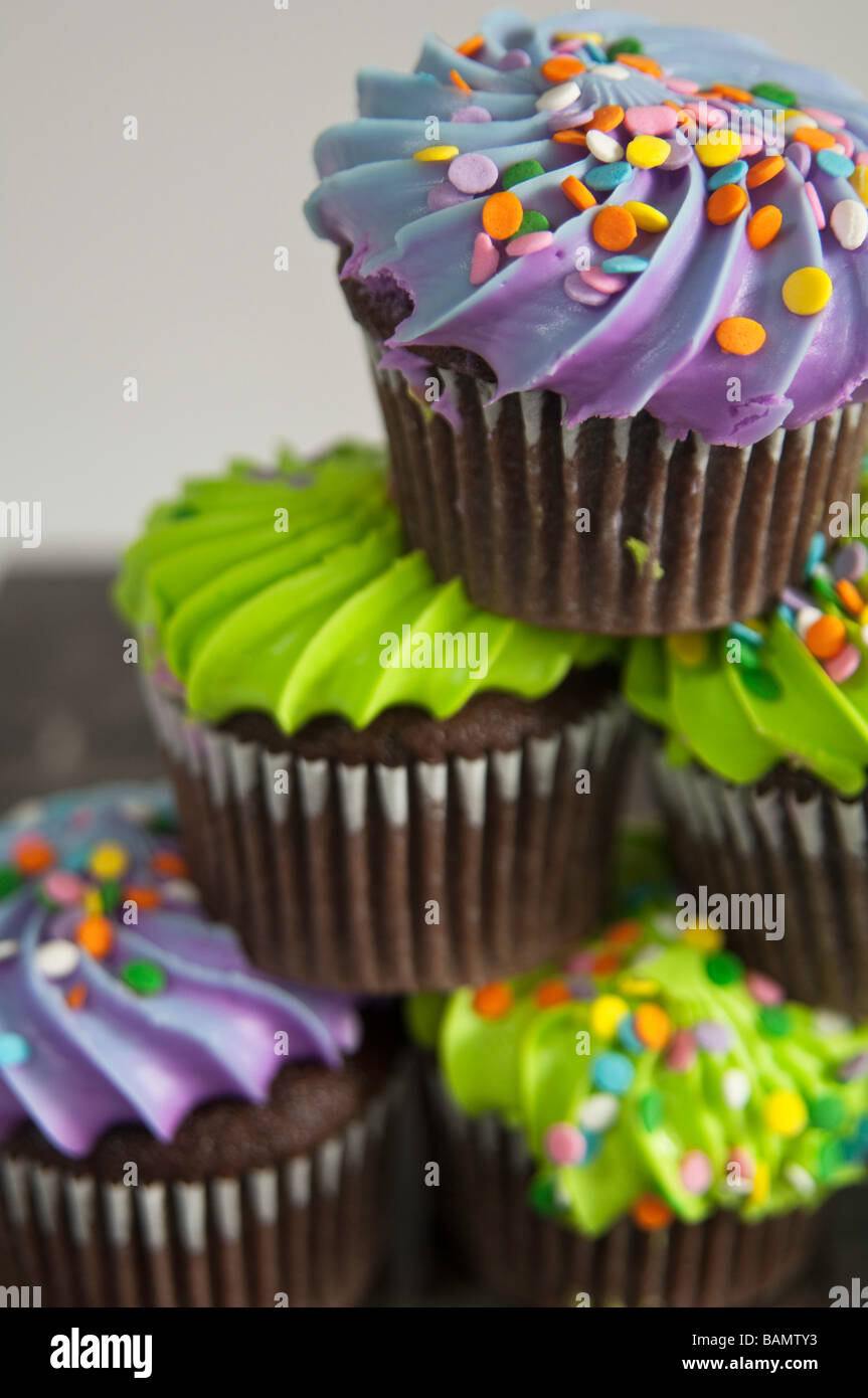 Cupcakes au chocolat et à la décoration colorée superposés en une pyramide, la satire de la "pyramide alimentaire" Banque D'Images