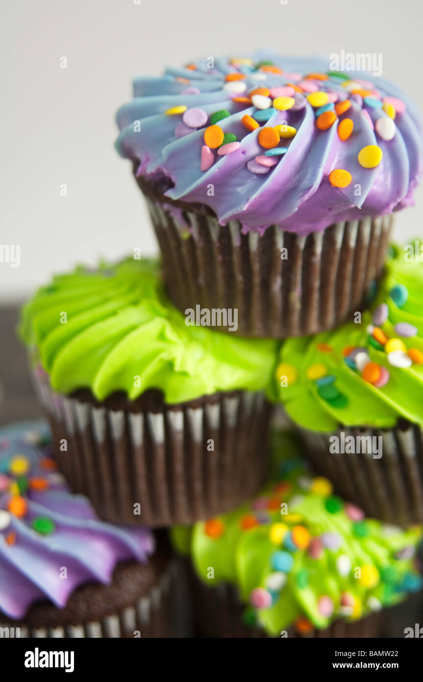 Cupcakes au chocolat et à la décoration colorée superposés en une pyramide, la satire de la "pyramide alimentaire" Banque D'Images
