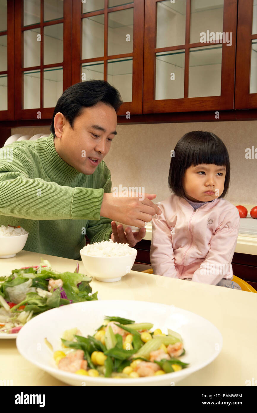 Homme essayant de nourrir sa fille Banque D'Images