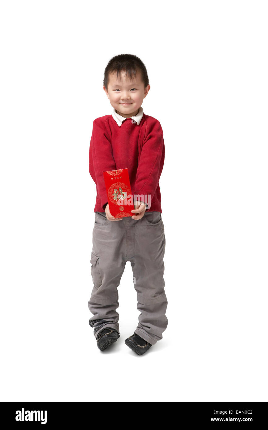 Un jeune garçon est titulaire d'une enveloppe rouge pour le Nouvel An chinois Banque D'Images