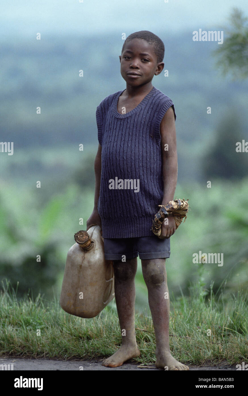 Boy carrying récipient de l'eau près du lac Kivu Rwanda Banque D'Images