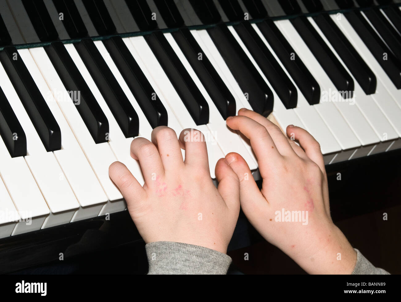Les petites mains d'enfant jouant du piano keys Banque D'Images