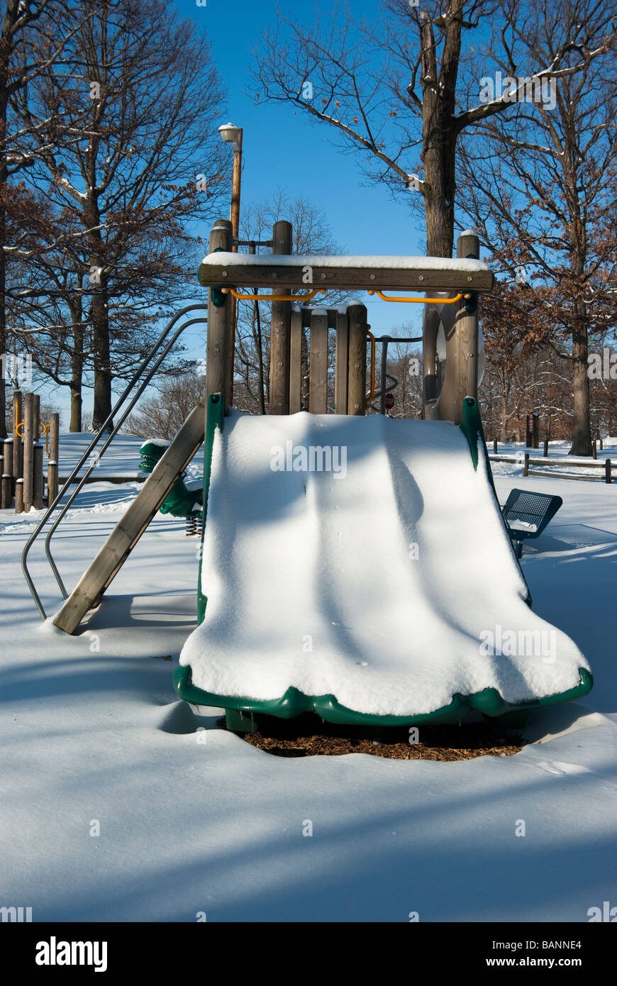 La neige glisse convered siéger non utilisée dans une aire de jeux après une tempête de neige Banque D'Images