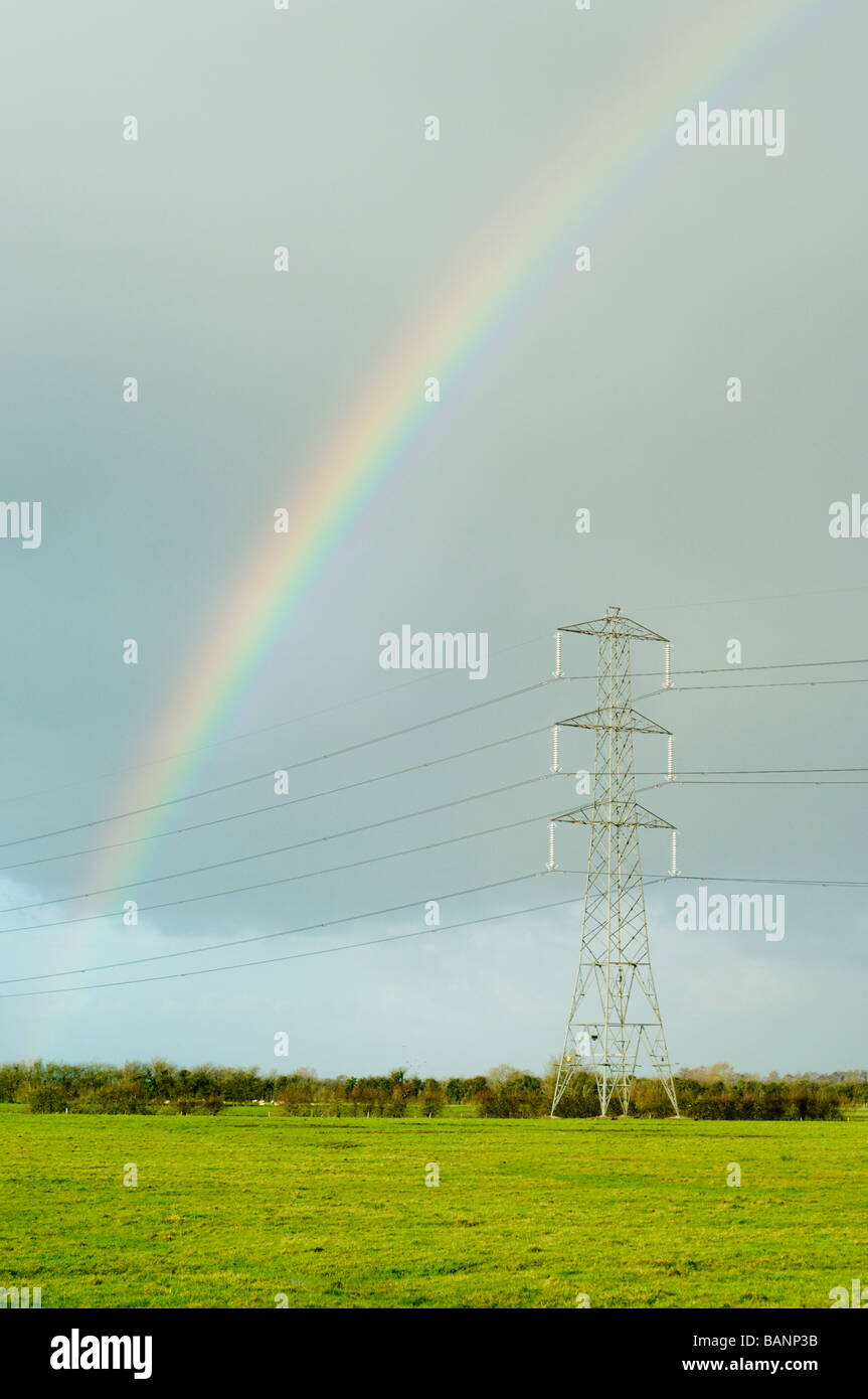 Les lignes de transport d'électricité, un pylône et un arc-en-ciel, sur les niveaux de Somerset, Angleterre. Banque D'Images