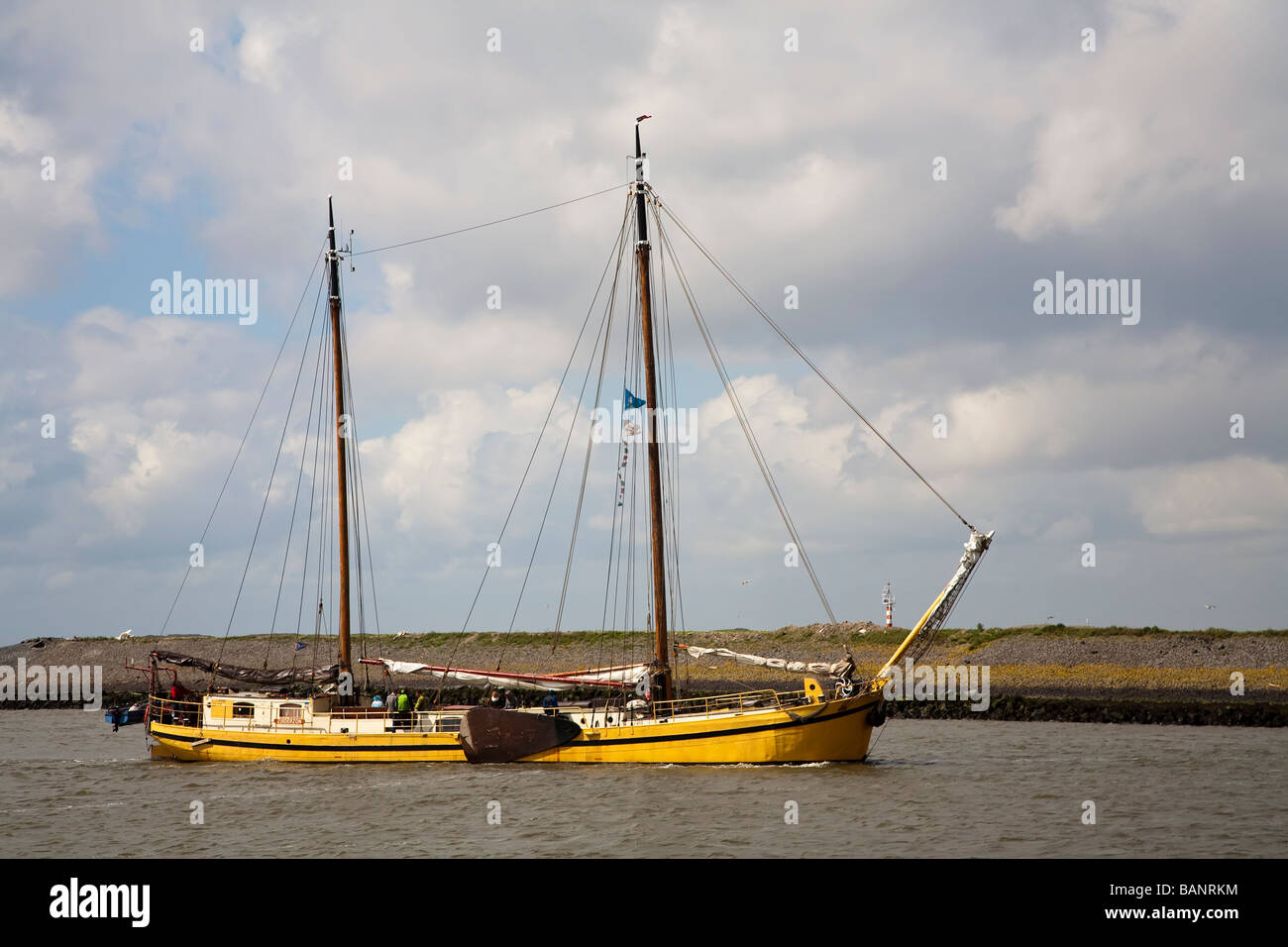 Bateau de pêche à coque jaune avec panneaux entrant harbour Harlingen Frise Pays-Bas Banque D'Images