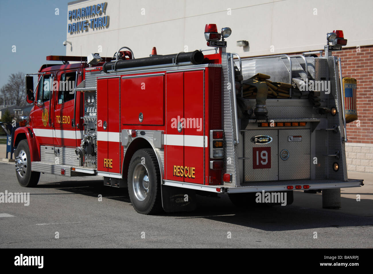 Camion de secours d'incendie rouge américain de côté près de personne sur la route de la ville aux États-Unis haute résolution Banque D'Images