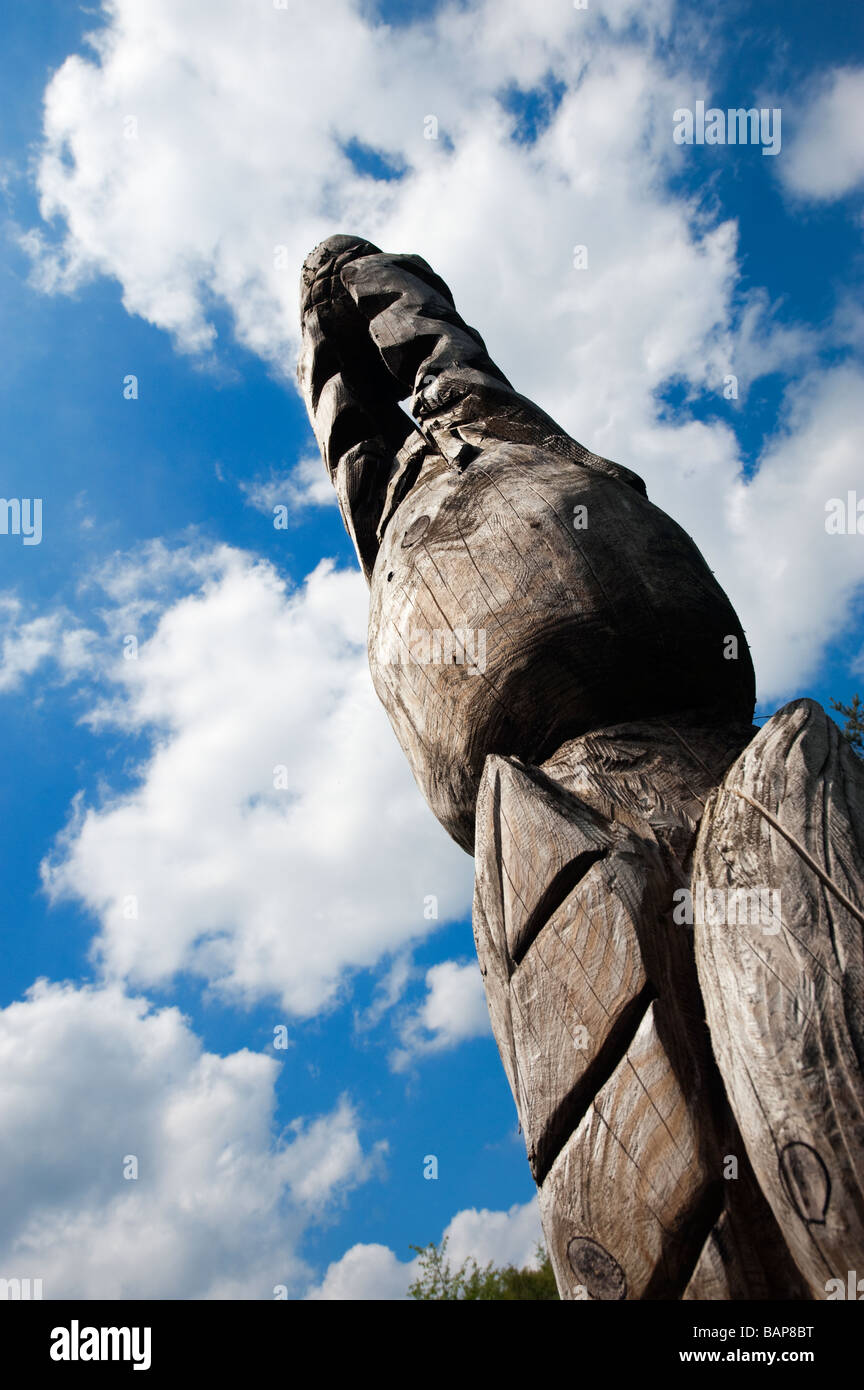 Totem en bois de sculpture et d'un ciel bleu avec des cumulus. Banque D'Images