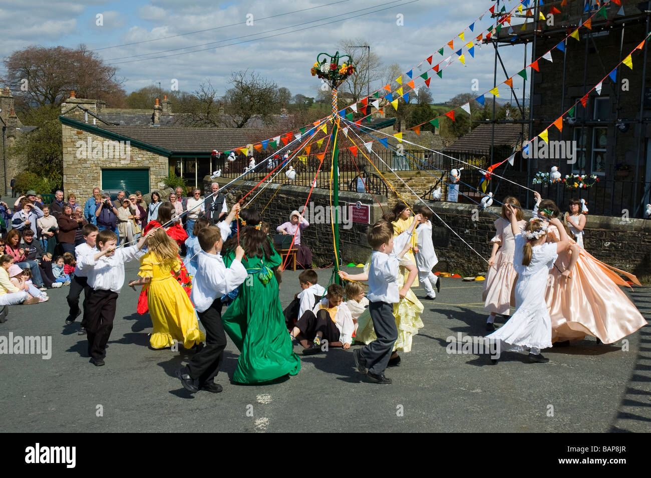 Les enfants dansant autour d'un mât au village de Wray, près de Lancaster, Angleterre, RU Banque D'Images