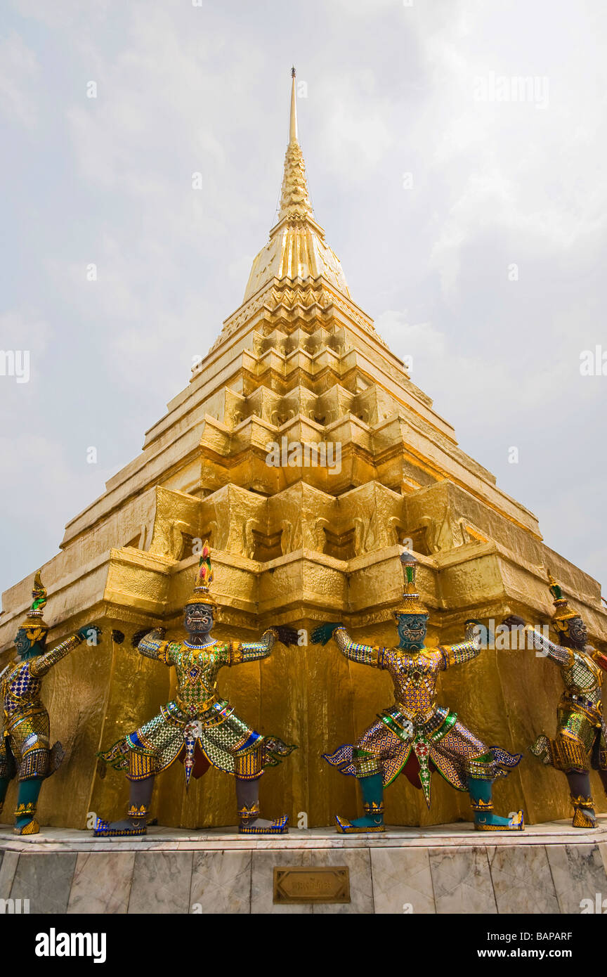 Les Démons mythologiques soutenant un grand chedi doré ou Stupa à Wat Phra Kaew, Bangkok, Thaïlande. Banque D'Images