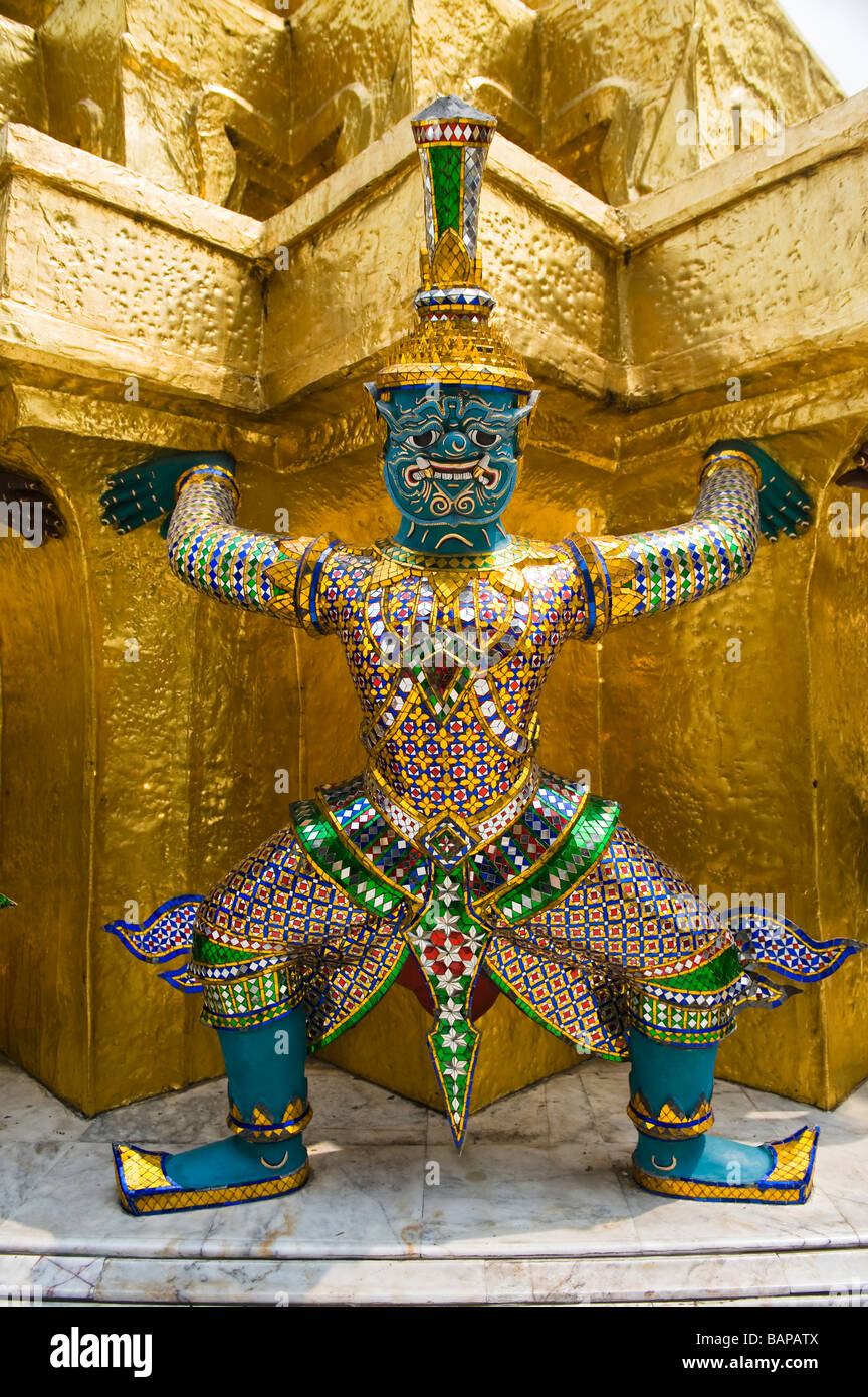 Close up d'un des démons mythologiques soutenant un grand chedi doré ou Stupa à Wat Phra Kaew, Bangkok, Thaïlande. Banque D'Images