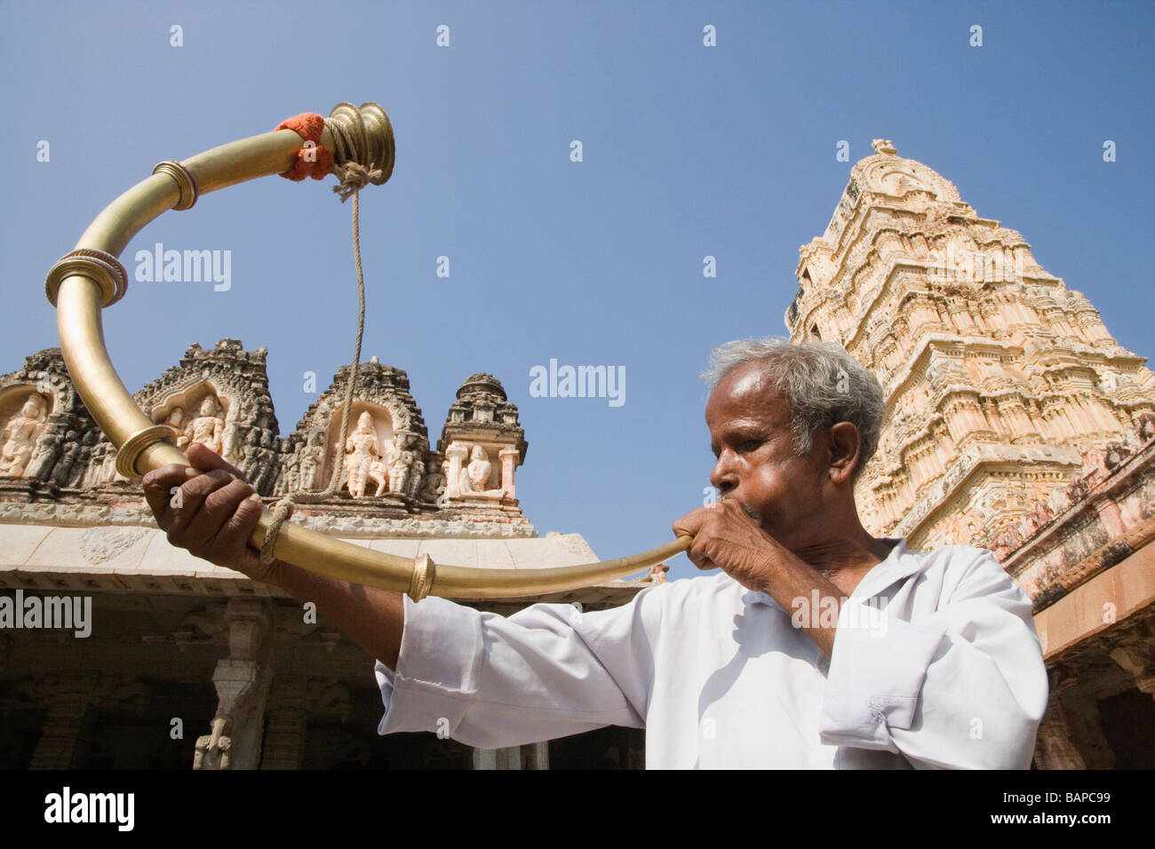 Homme soufflant une corne devant un temple, temple de Virupaksha, Hampi, Karnataka, Inde Banque D'Images