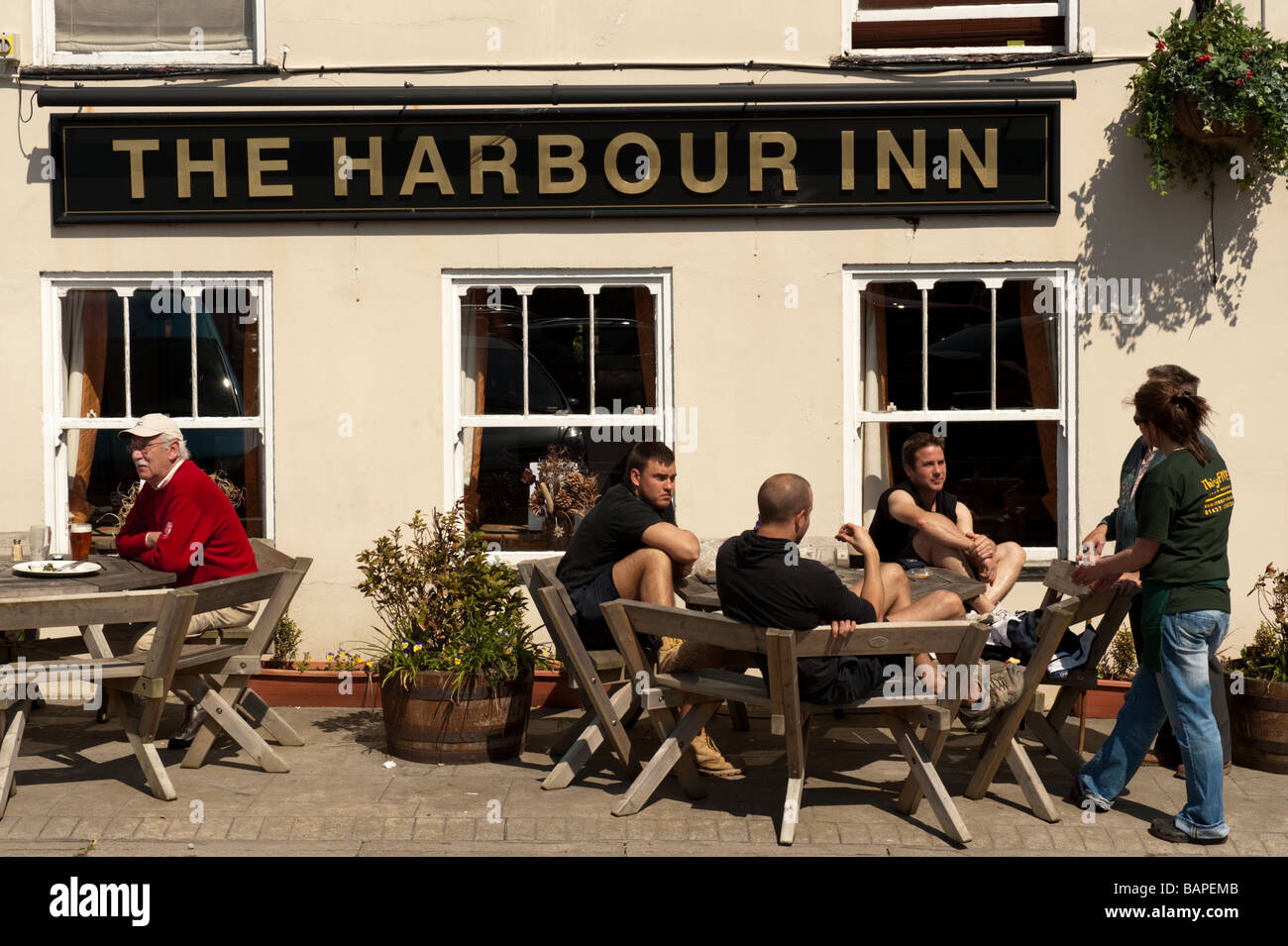 Groupe de gens assis à l'extérieur de l'Harbour Inn pub Solva Pembrokeshire Coast National Park Port Wales UK Banque D'Images
