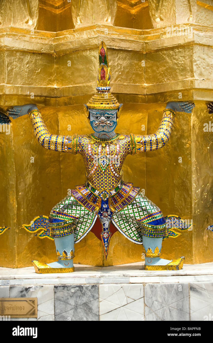 Close up d'un des démons mythologiques soutenant un grand chedi doré ou Stupa à Wat Phra Kaew, Bangkok, Thaïlande Banque D'Images