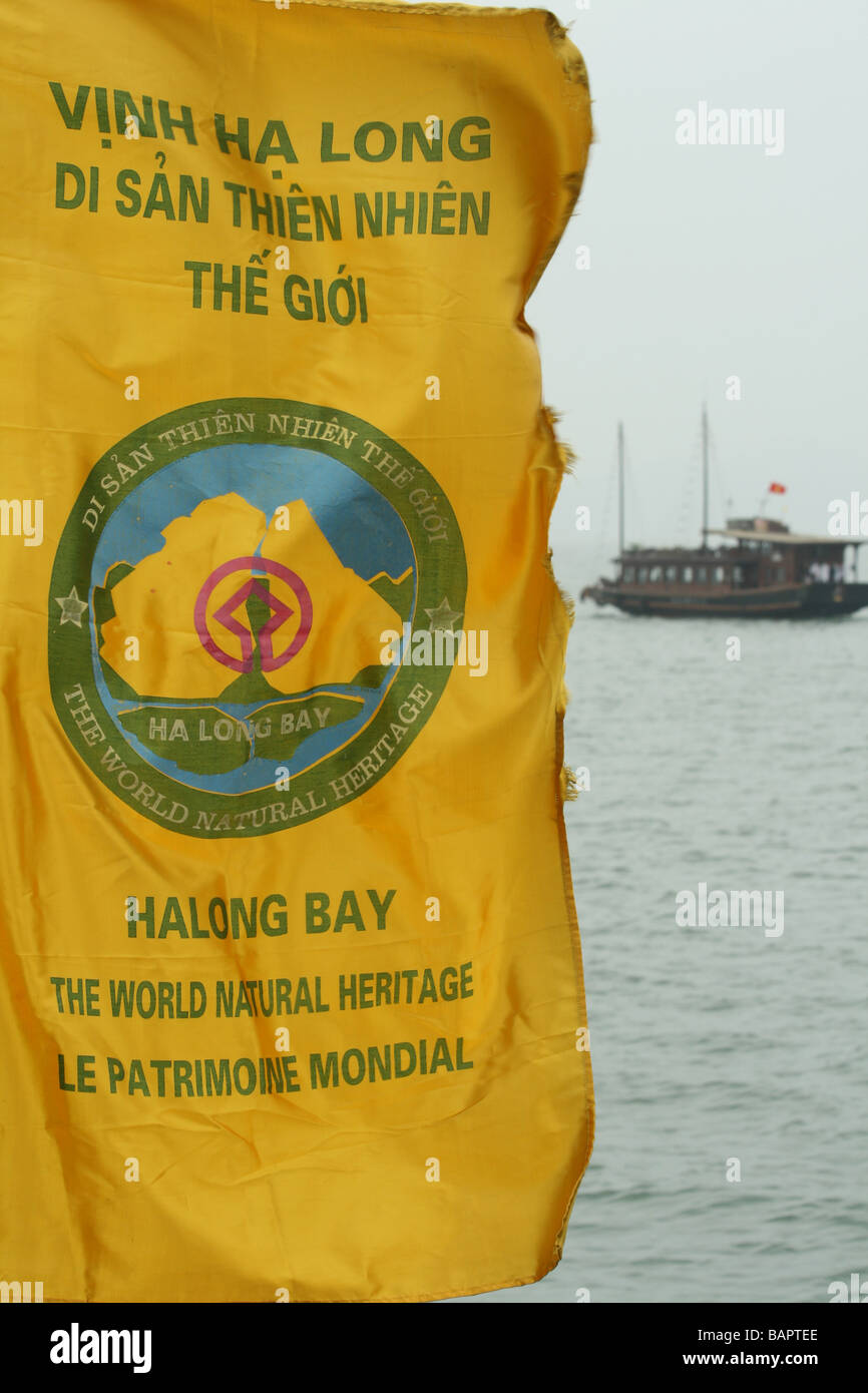 Un drapeau qui flotte en Baie d'Halong, Vietnam avec un bateau de tourisme dans l'arrière-plan Banque D'Images