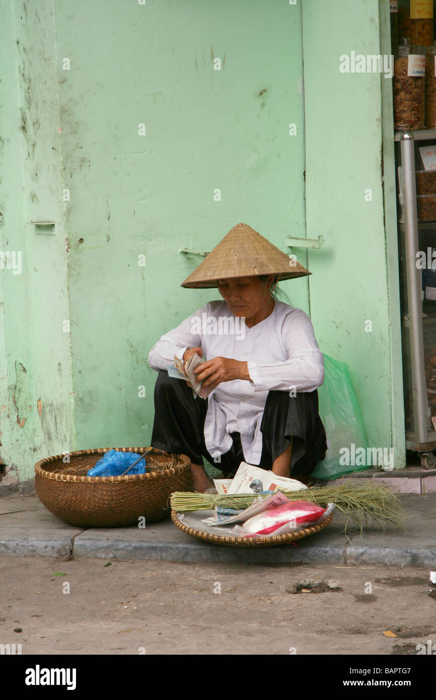 Femme âgée passant le temps dans les rues de Hanoi, Vietnam Banque D'Images