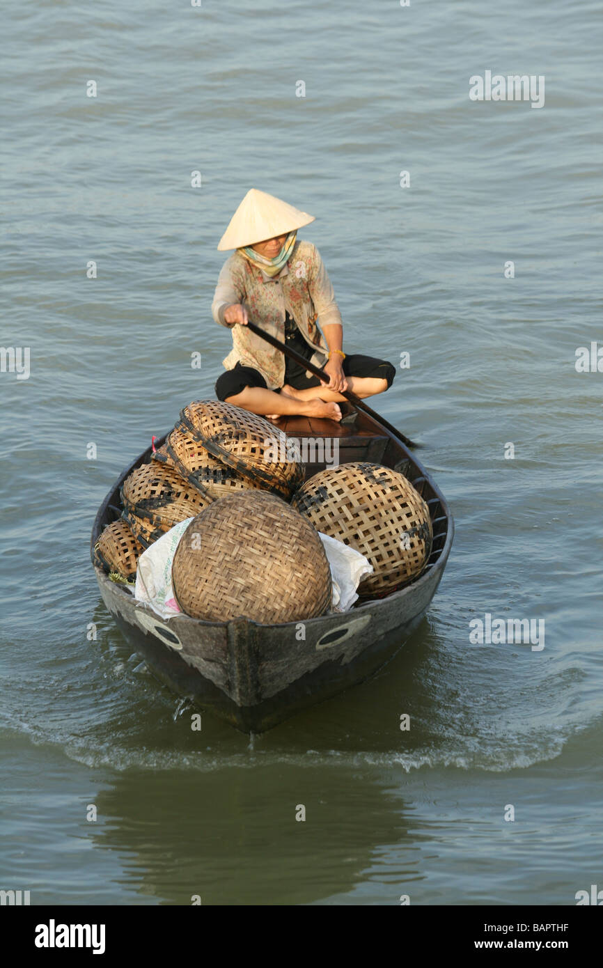 Une vieille dame revient à Hoi An au Vietnam en bateau avec ses prises de poisson du jour Banque D'Images