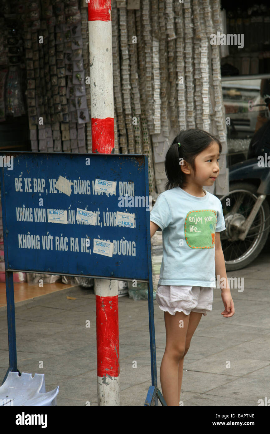 Une jeune fille joue à l'extérieur de son domicile dans les rues de Hanoi, Vietnam Banque D'Images