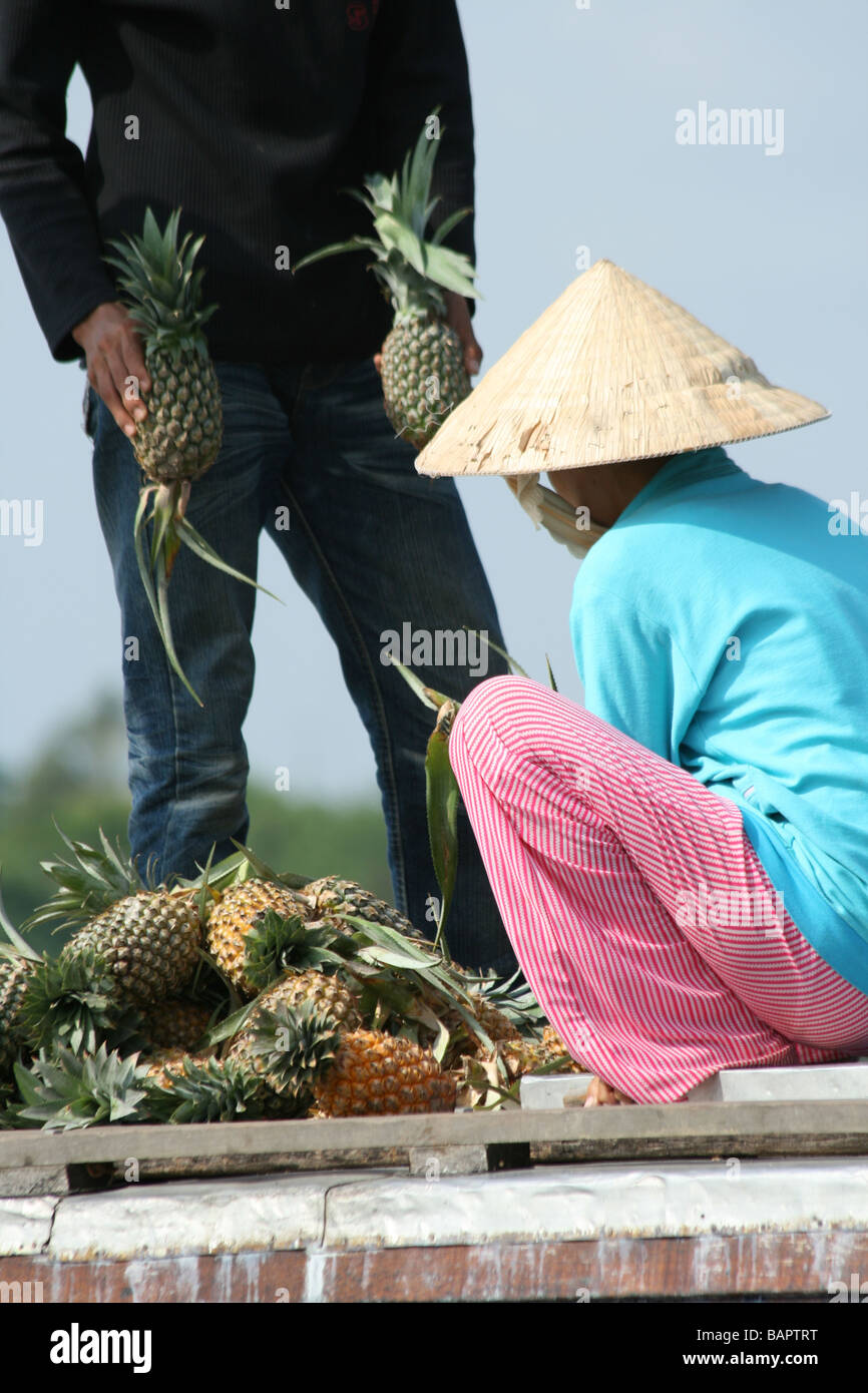 Un ananas vendeur vend des fruits au marché flottant dans le Delta du Mekong, Vietnam Banque D'Images