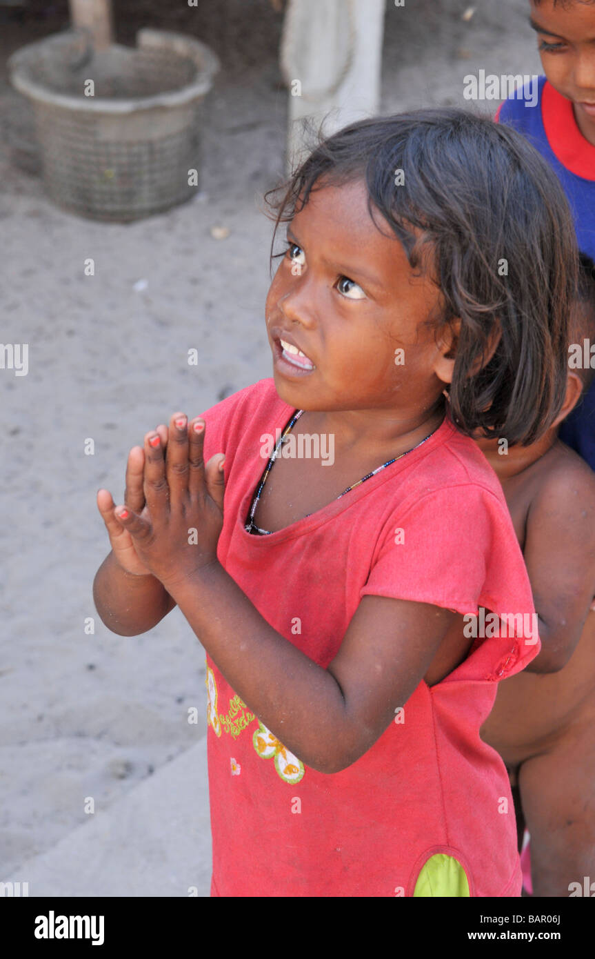 Enfants Moken mettre paumes ensemble wai et la queue pour obtenir de l'doux, Koh Phayam, Ranong, Thaïlande du sud. Banque D'Images