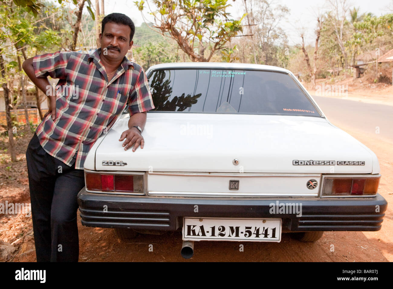 Chauffeur de taxi avec sa voiture Maruti Esteem Kerala Inde Banque D'Images
