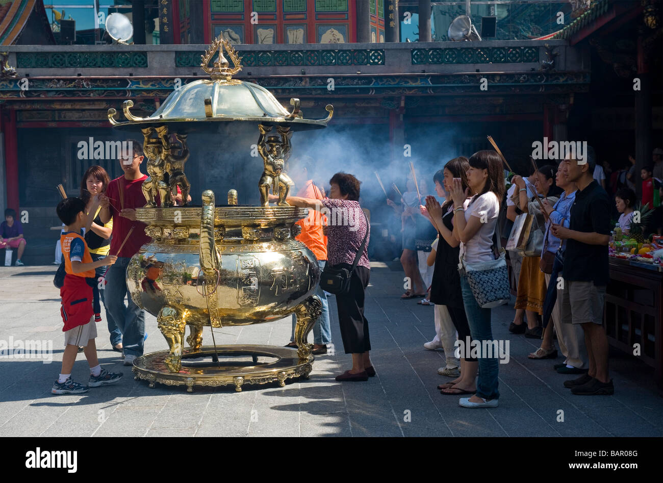 Les fidèles Bouddhistes et Taoïstes d'encens brûlant comme un rituel offrant au Mengjia Temple Lungshan. Taipei, Taiwan. Banque D'Images