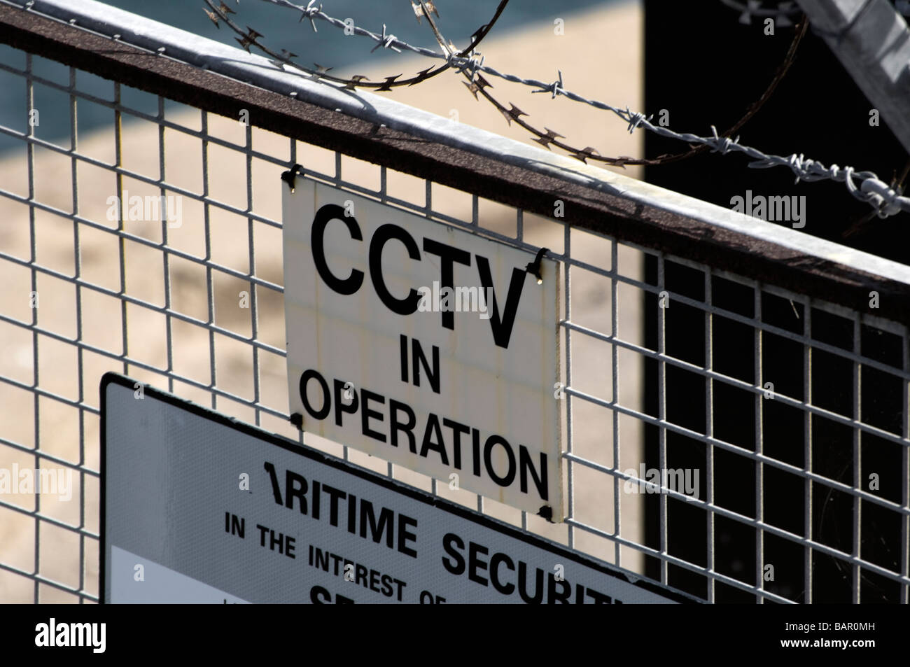 Panneau d'avertissement de CCTV et clôture surmontés de barbelés protégeant une partie du port de Weymouth, dans le Dorset, Angleterre. Banque D'Images
