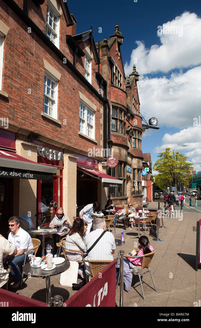 UK Angleterre Cheshire Alderley Edge London Road clients assis sur le trottoir devant le Costa Coffee Banque D'Images