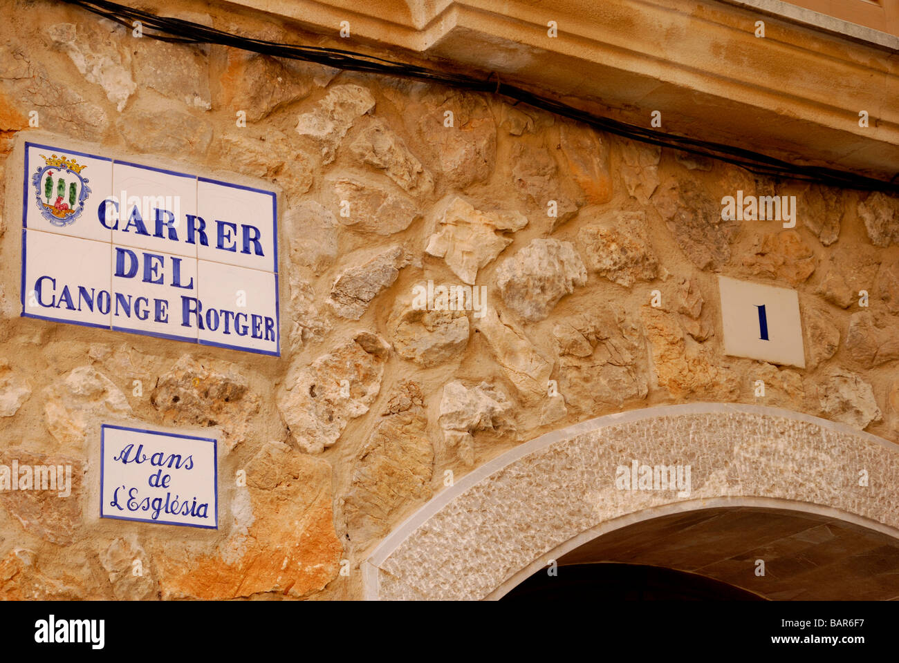 Close-up of street sign en Catalan situé dans mur de pierre en Pollensa, Mallorca Banque D'Images