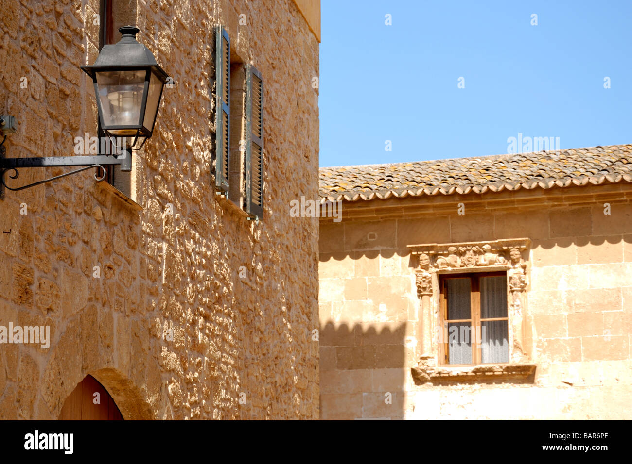 Les bâtiments en pierre et la bonne vieille lampe de rue à Alcudia, Majorque Banque D'Images