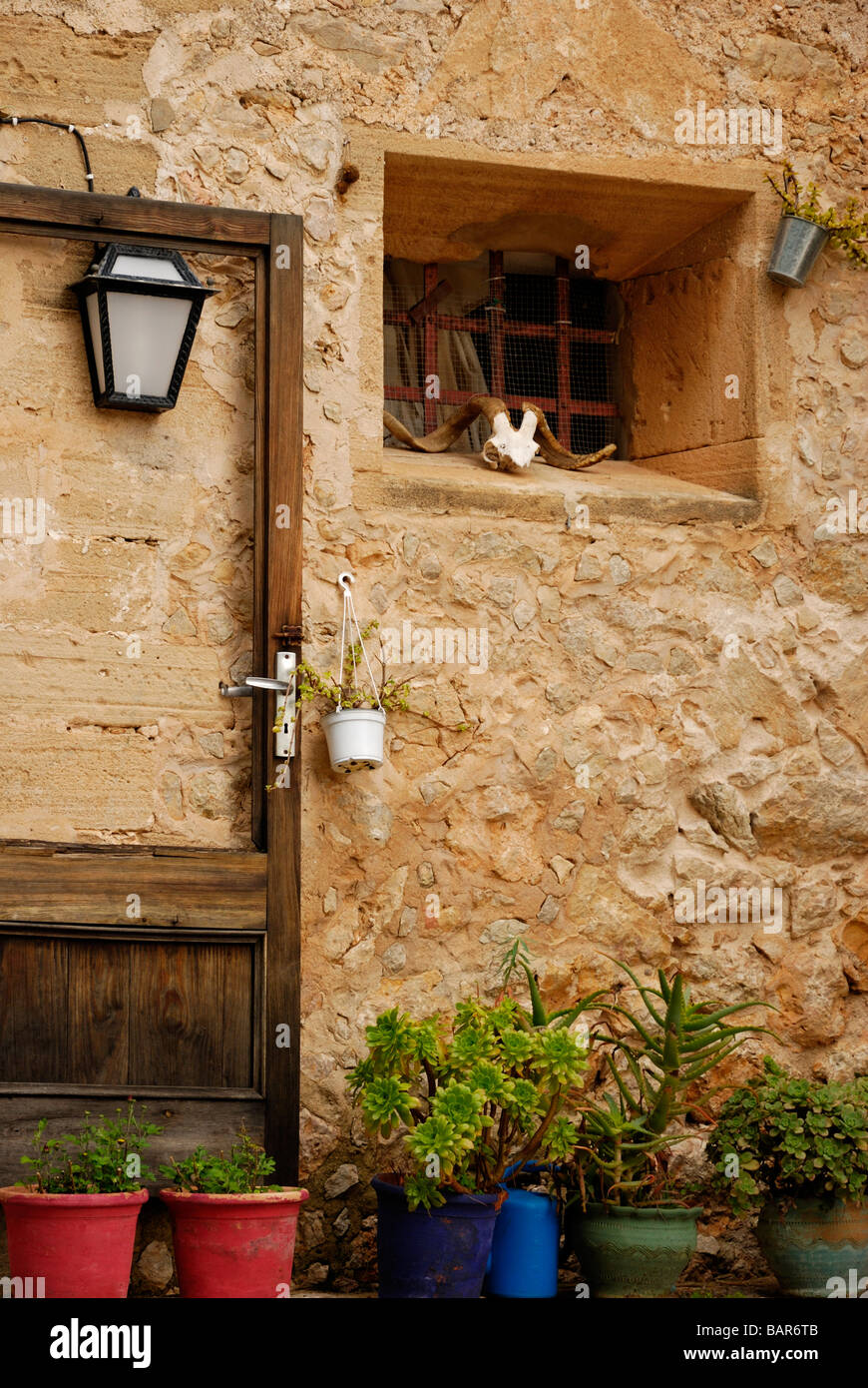 Maison en pierre rustique à l'ancienne avant avec lampe et plantes en pot Banque D'Images