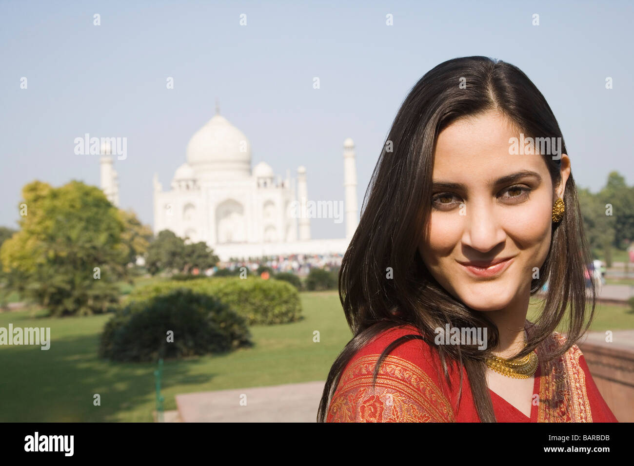 Portrait of a woman smiling with un mausolée dans l'arrière-plan, Taj Mahal, Agra, Uttar Pradesh, Inde Banque D'Images