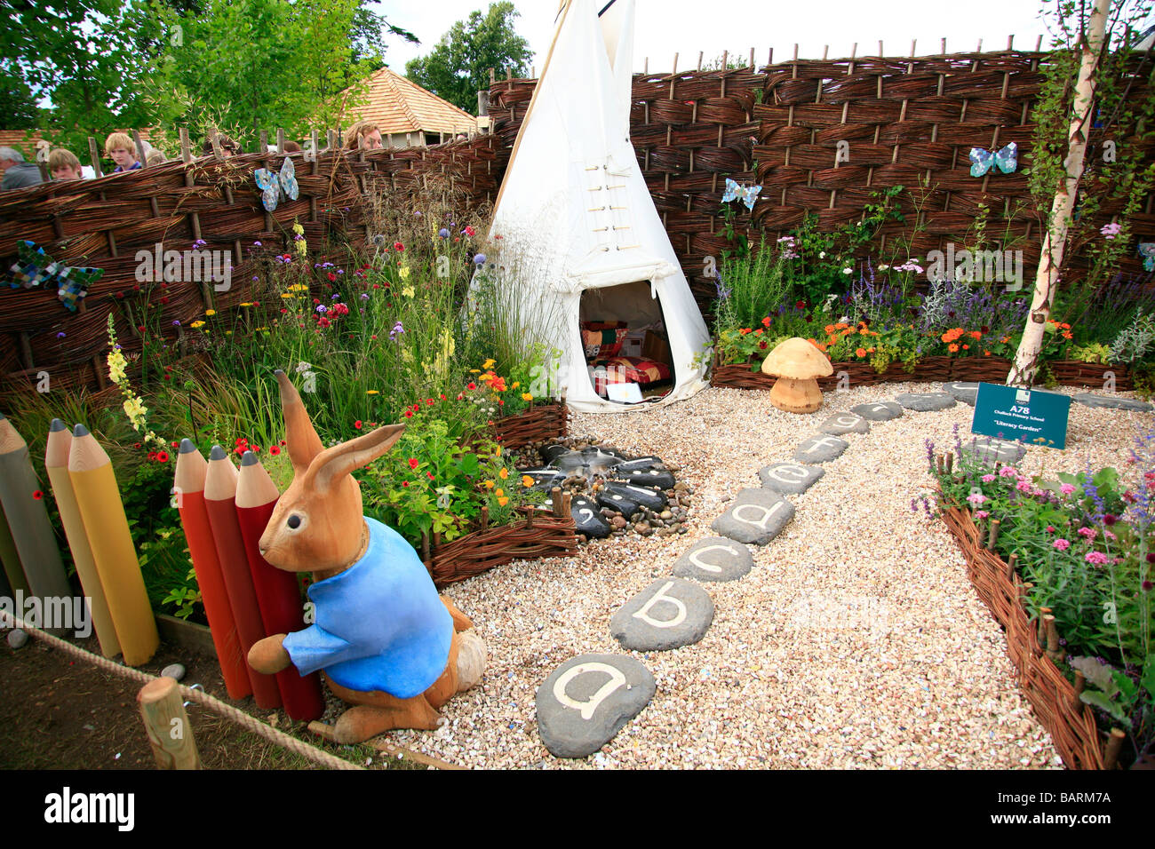 Le jardin d'apprentissage pour les enfants avec les lettres des tremplins,wendy house et sculpture de lapin. Plantés de vivaces frontières Banque D'Images