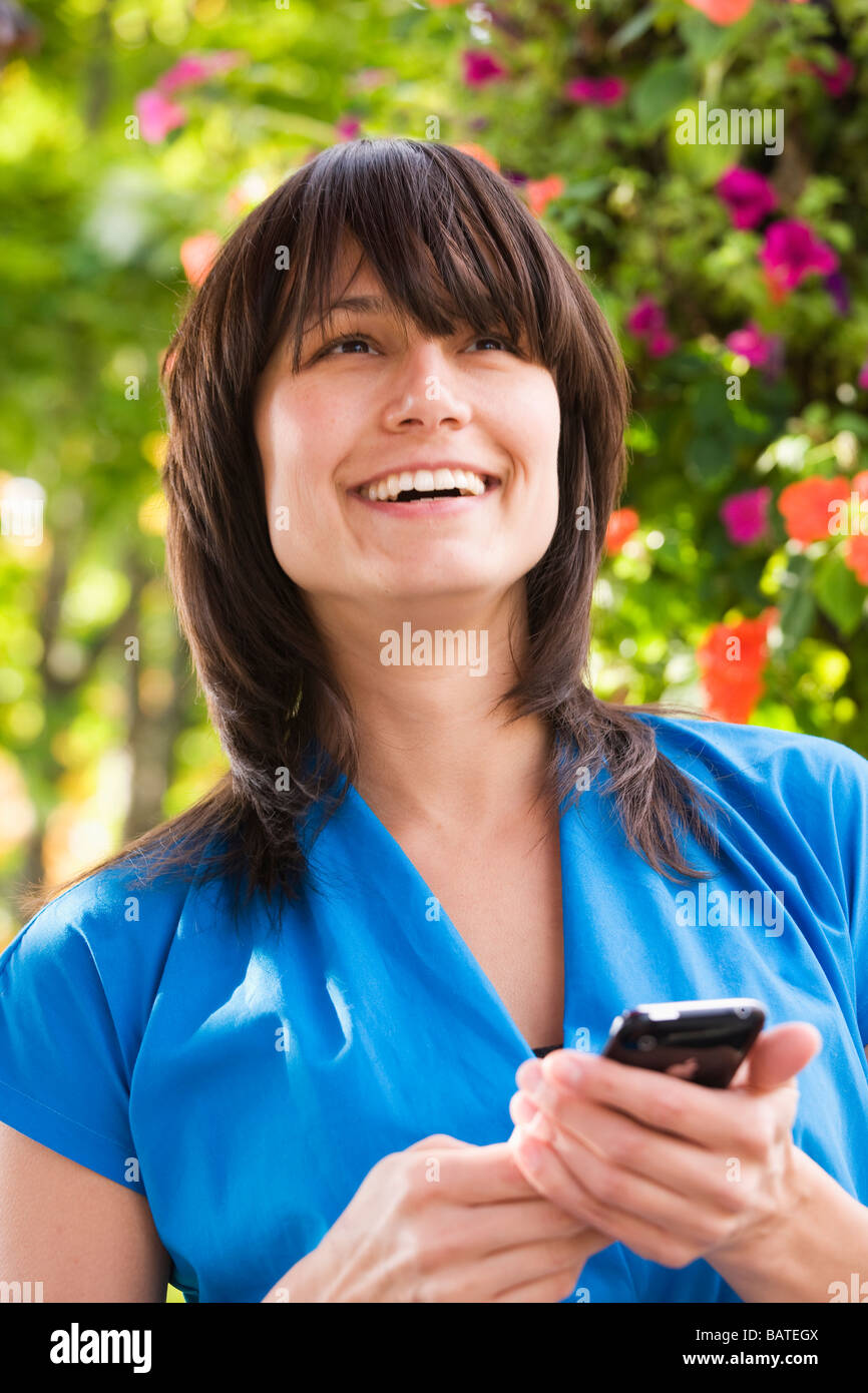 Mixed Race woman text messaging on cell phone Banque D'Images