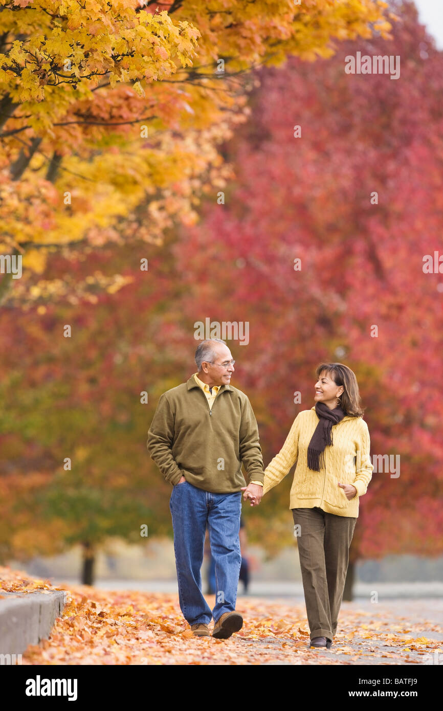 Hispanic couple holding hands outdoors in autumn Banque D'Images