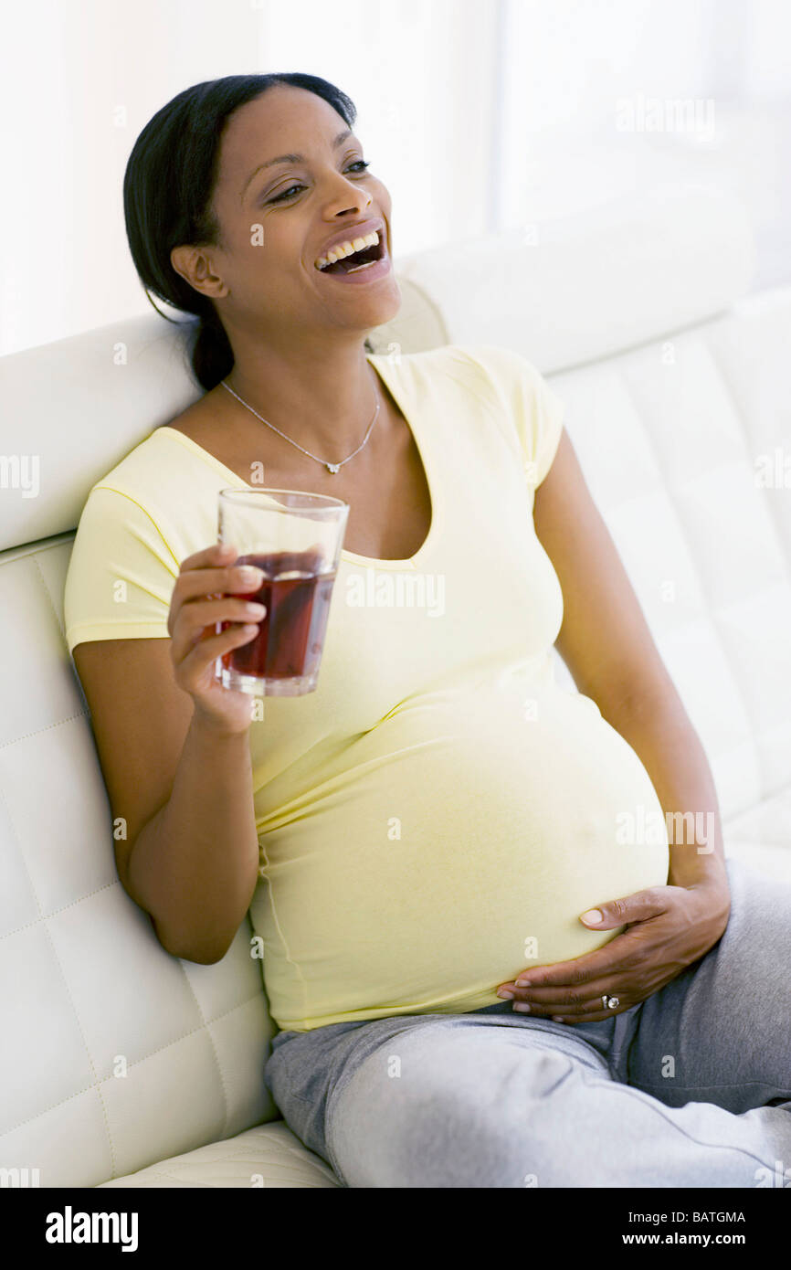 Femme enceinte en riant tout en tenant un verre de jus de canneberge. Elle  est à terme Photo Stock - Alamy