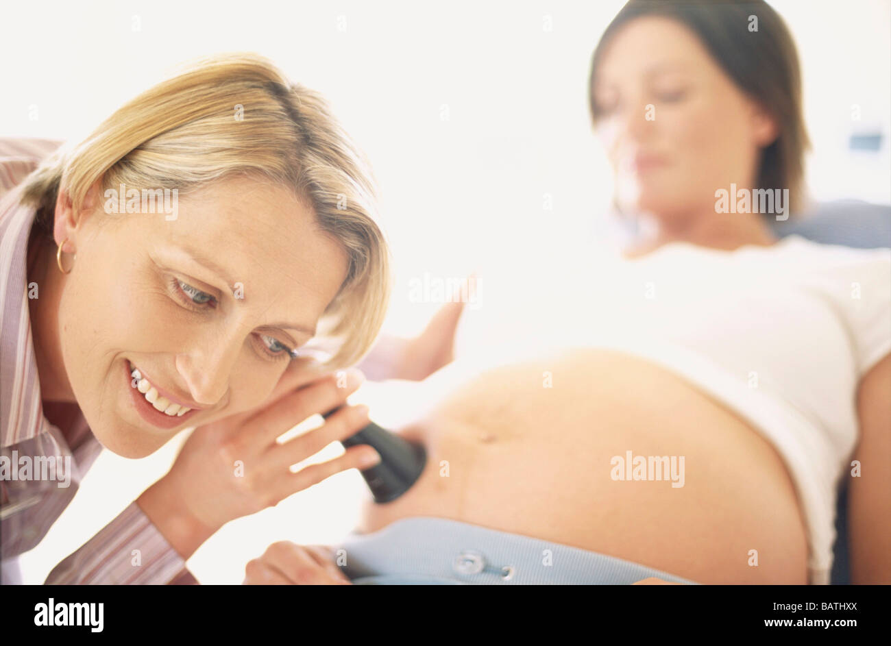 Examen obstétrique. Sage-femme(à gauche) à l'aide d'une oreille corne pressé à un pregnantwoman Banque D'Images