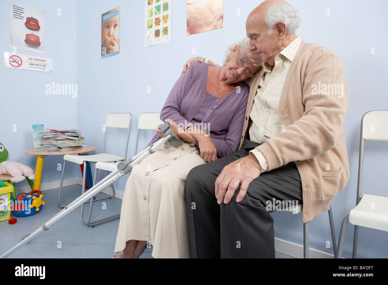 Couple de personnes âgées réconfortant mutuellement dans une pratique générale salle d'attente. Banque D'Images