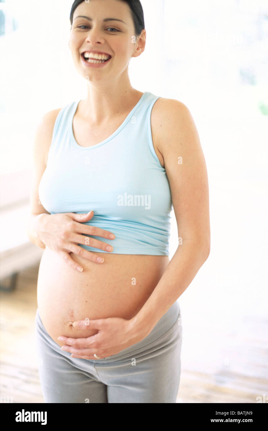 Pregnant woman holding le bas de son dos. Elle a huit mois (32 semaines)  enceinte. Le mal de dos est fréquent en fin de grossesse Photo Stock - Alamy