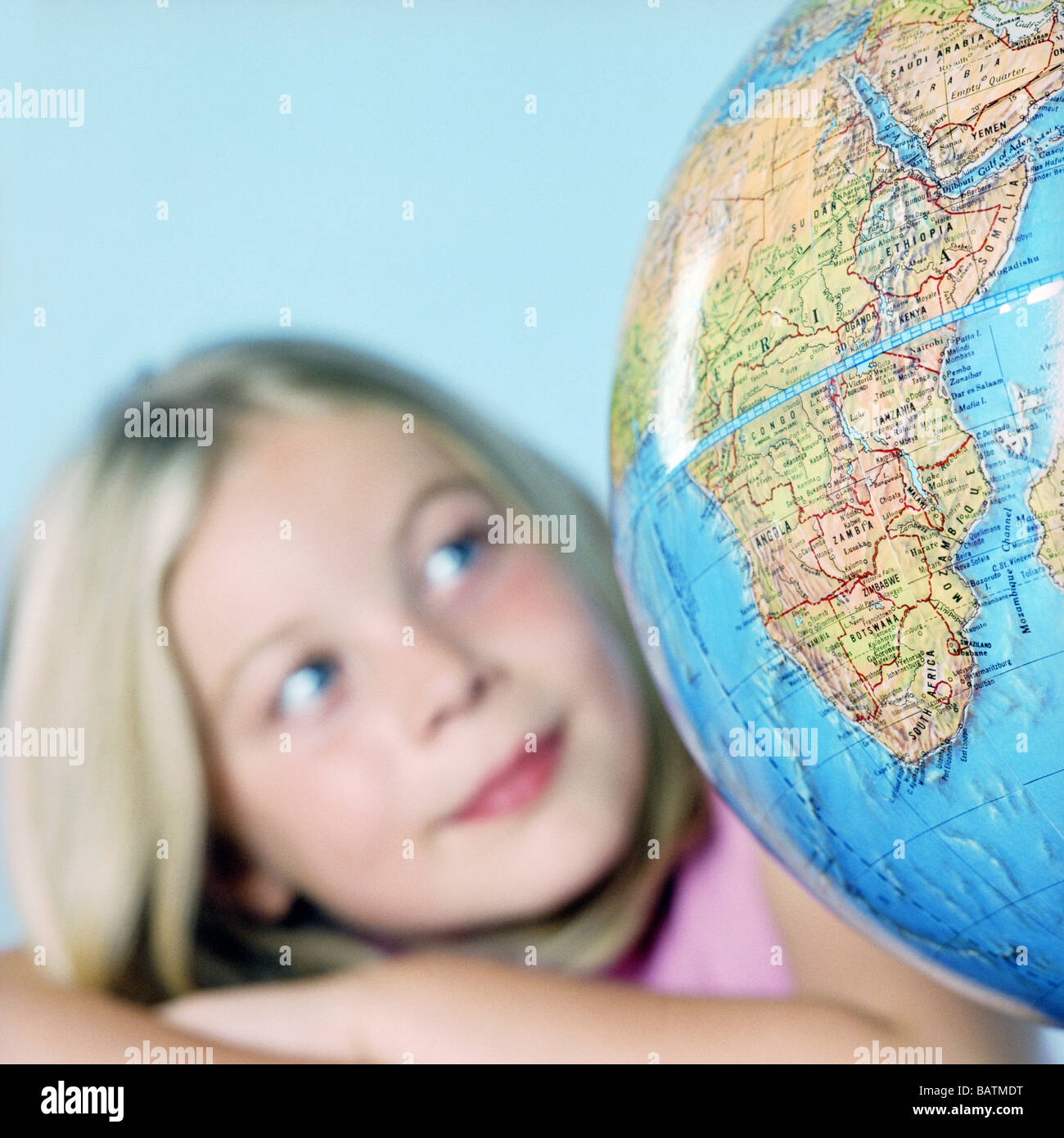 S'interroger sur le monde. Sept ans, fille d'étudier un globe. Banque D'Images