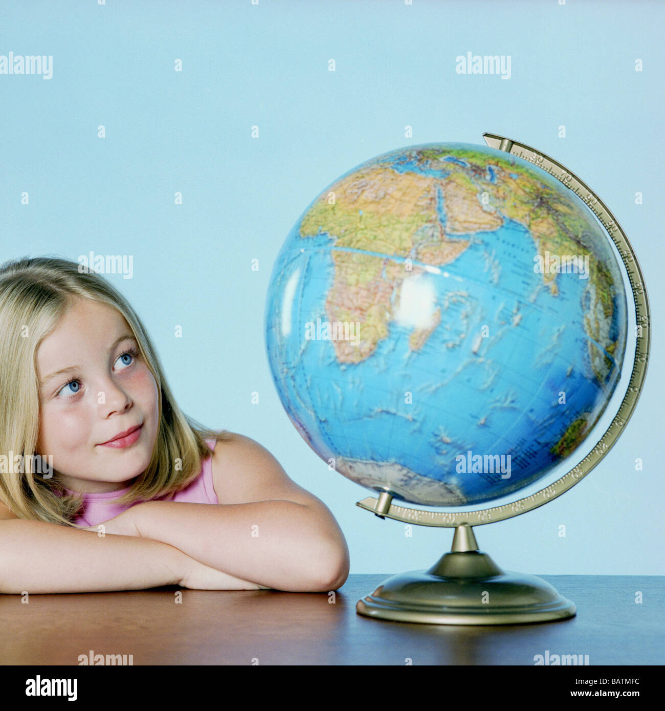 S'interroger sur le monde. Sept ans, fille d'étudier un globe. Banque D'Images