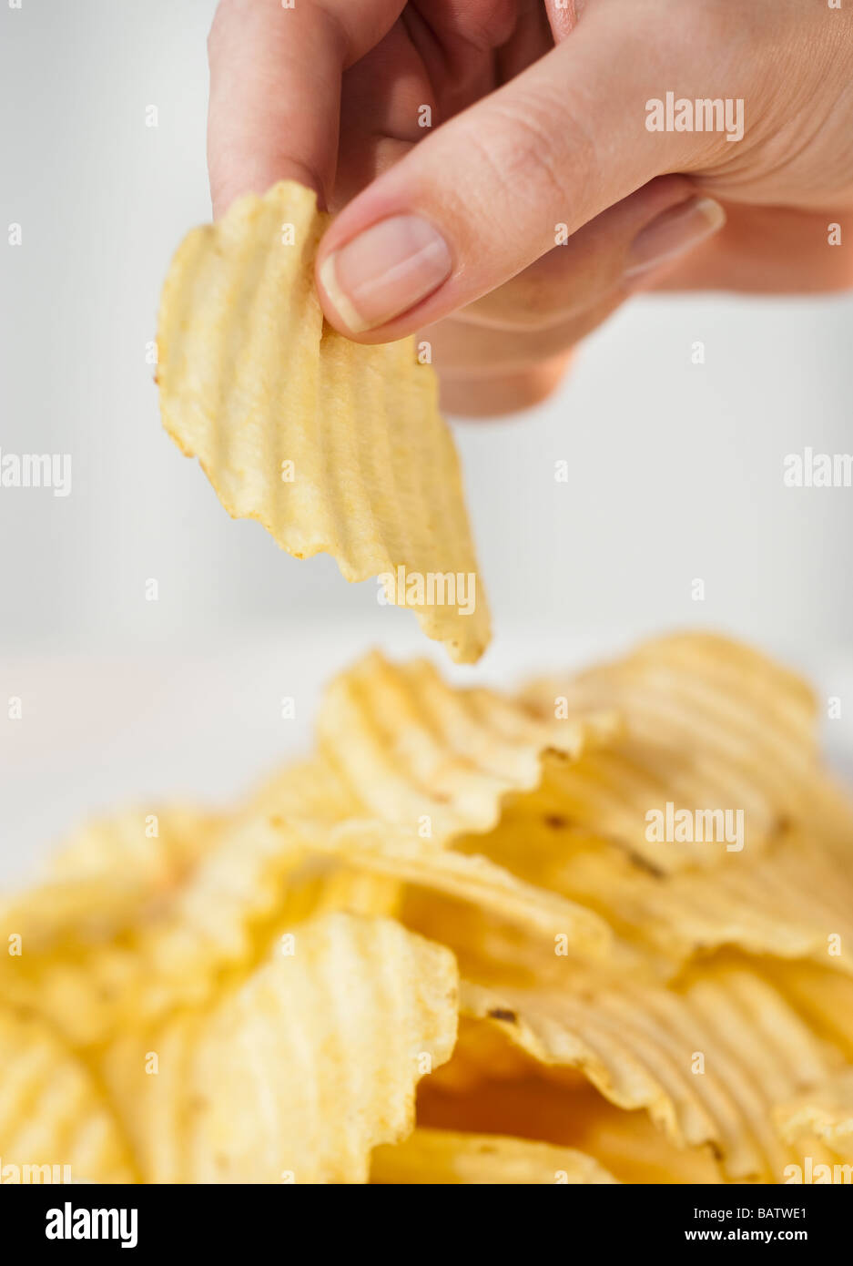 Woman's hand taking potato chip Banque D'Images