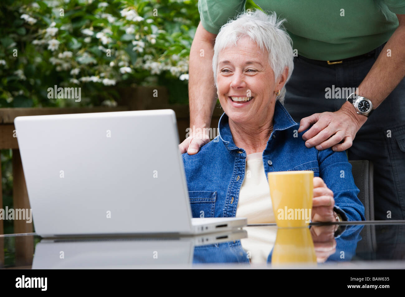 Senior couple looking at laptop outdoors Banque D'Images