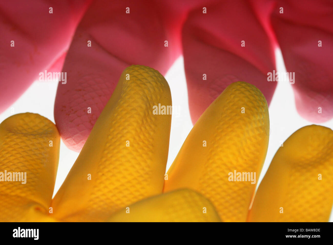 En plastique jaune et rose gants en caoutchouc qui se touchent d'autres Banque D'Images